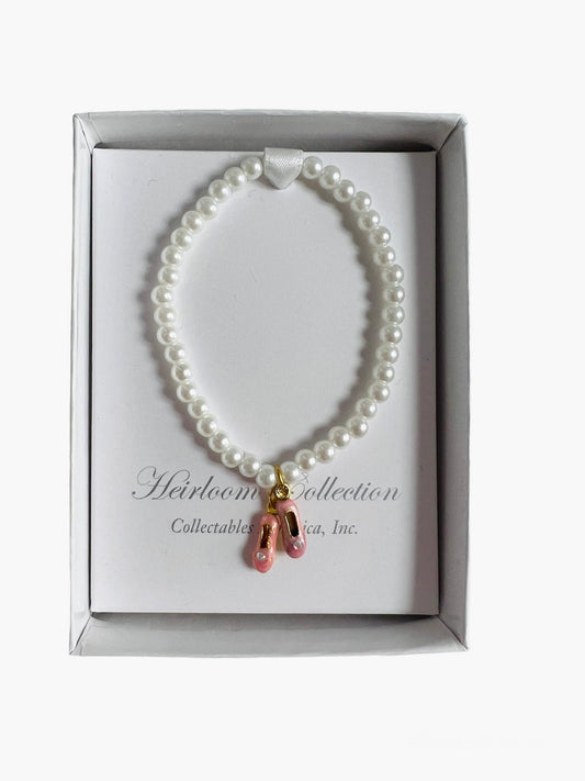 A Pink Pearl Ballet Shoe Bracelet with a gold charm by Collectables America.